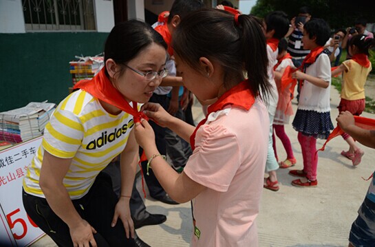 捐贈儀式上，孩子們?yōu)閻坌奶焓瓜瞪霞t領巾