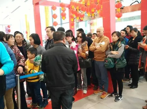 排隊(duì)領(lǐng)年貨，一家老小齊上陣。