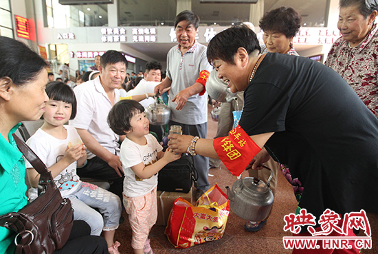 老年雷鋒團”志愿者在候車廳為旅客送水。