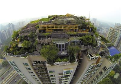 　　昨日，身穿橘黃色馬甲的工作人員在人濟(jì)山莊樓頂拆除違章建筑。新京報(bào)記者 吳江 攝