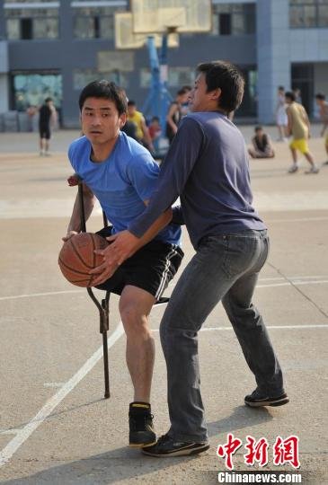 圖為拄著拐杖的瞿詩(shī)濤和同學(xué)搶球。劉占昆攝