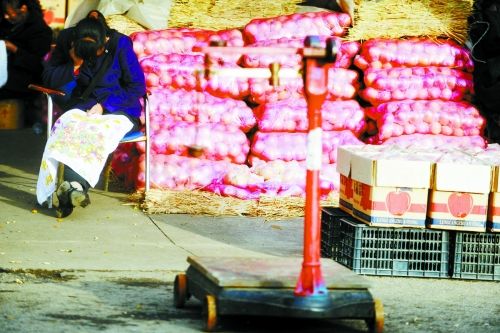 水果批發(fā)市場(chǎng)內(nèi)，沒(méi)有客戶(hù)時(shí)，商戶(hù)在繡十字繡