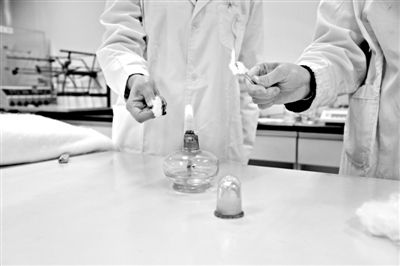 實驗人員操作的燃燒檢測法中，真蠶絲離開火焰就熄滅(左)。