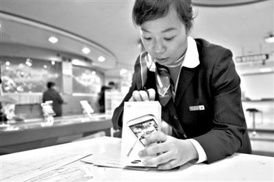 11月6日，北京移動西直門營業(yè)廳的工作人員在為顧客購買的4G手機(jī)登記。新華社發(fā)