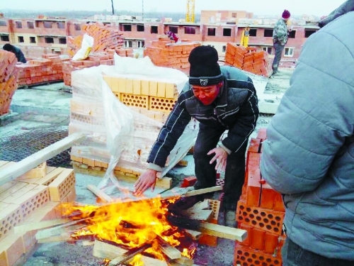 在俄羅斯工地打工時(shí)，因?yàn)樘焯?，工人不得不在工地生火取暖。（圖由方先生提供）