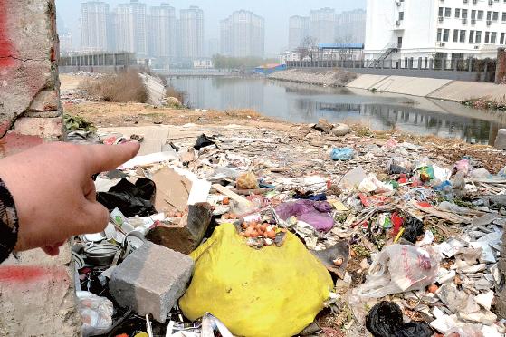 金水河長江路橋下河水發(fā)臭，水邊堆放眾多垃圾