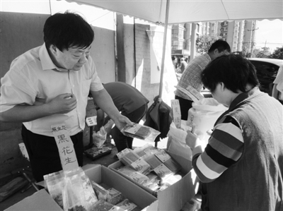 昨日，河南企業(yè)家劉春喜在京“練攤”，為顧客挑選綠豆。新京報記者 張玉學(xué) 攝