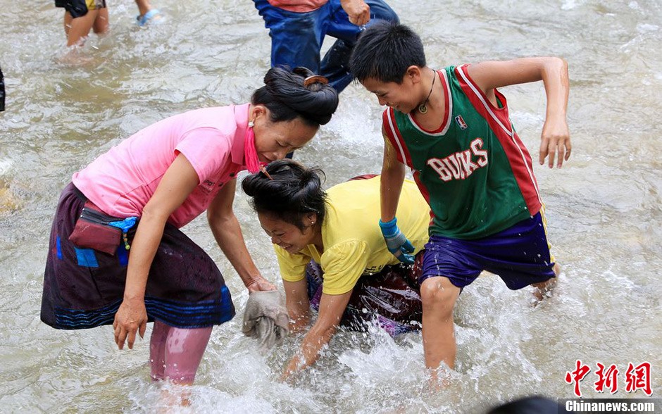 7月9日，村民在小河里摸魚搶魚。譚凱興 攝