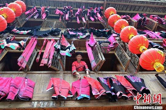 圖為紅瑤姑娘把紅衣晾曬出來(lái)。中新社發(fā) 韋吉陽(yáng) 攝