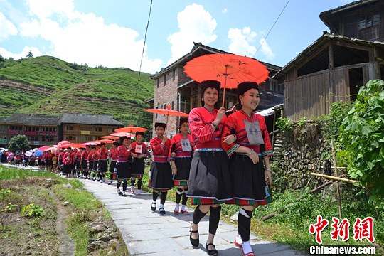 圖為新娘身著瑤族盛裝在伴娘和親友的陪伴下“出嫁”。中新社發(fā) 韋吉陽(yáng) 攝