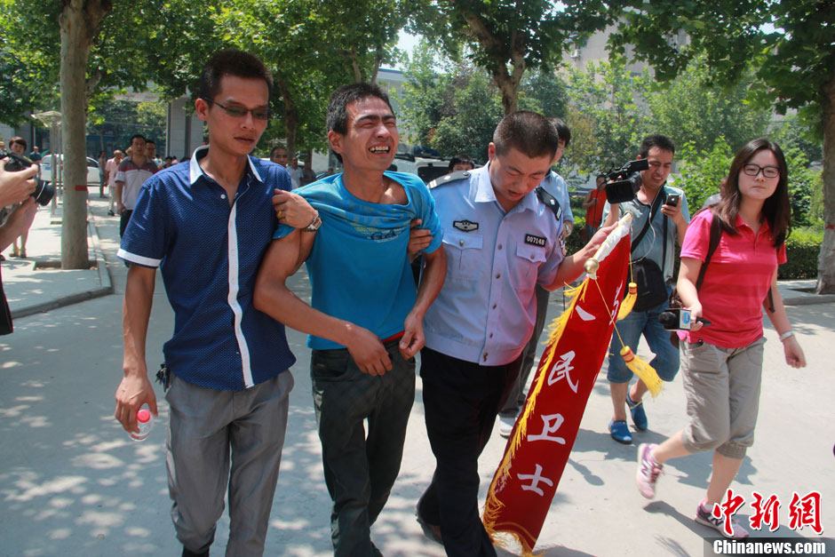 圖為獲救嬰兒父親情緒一度失控，當?shù)鼐焦ぷ魅藛T對其進行攙扶。張一辰 攝