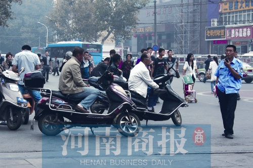 　火車站廣場北側(cè)，幾輛摩的正在等客