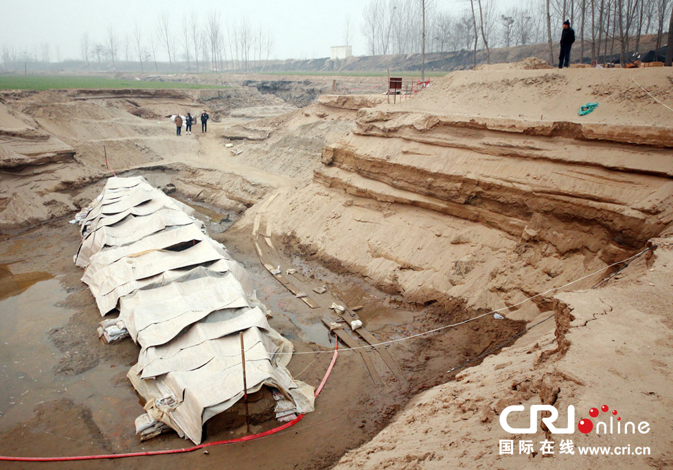 2014年1月6日，河南洛陽古沉船發(fā)掘現(xiàn)場，近日有雨雪天，考古人員給古沉船披上一層“雨衣”。