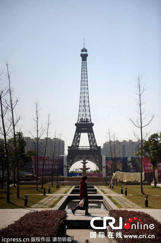 　2014年3月21日，杭州天都城，農民在山寨埃菲爾鐵塔下耕作。圖片來源：東方IC