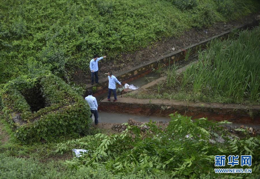 5月18日，工作人員在槽罐車泄漏現(xiàn)場附近的水渠邊查看情況。