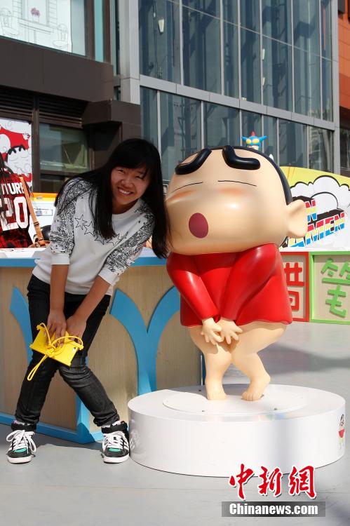 4月22日，游客與蠟筆小新合影?！跋灩P小新25周年紀(jì)念特展”日前在北京開(kāi)展，吸引了不少市民游客。