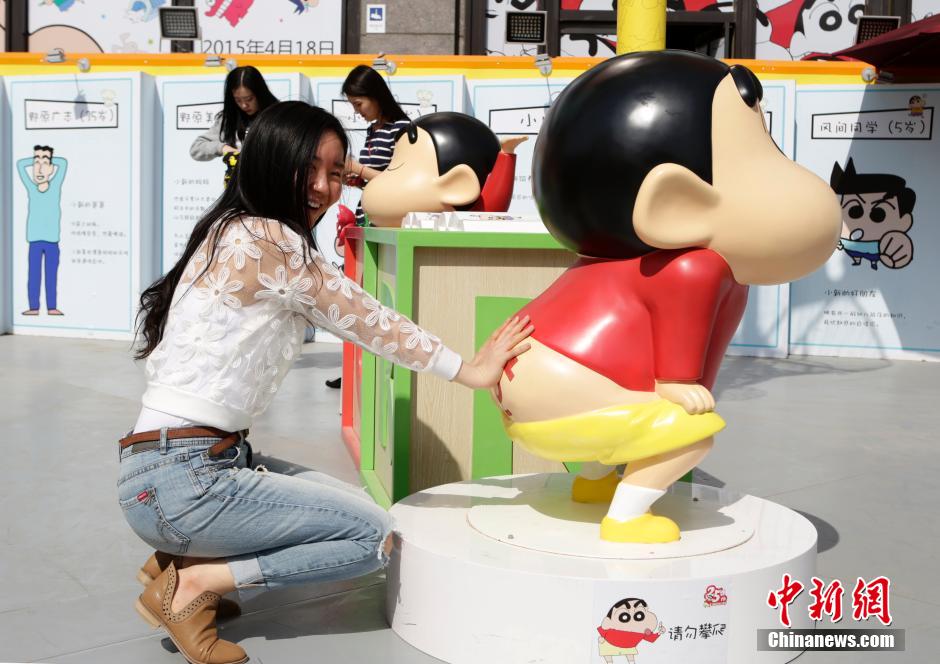 4月22日，游客與蠟筆小新合影?！跋灩P小新25周年紀(jì)念特展”日前在北京開(kāi)展，吸引了不少市民游客。