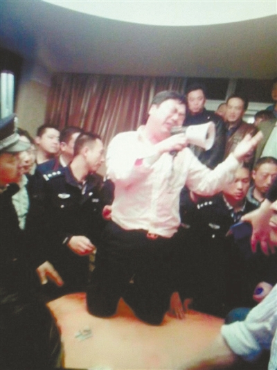 　4月19日，泰州市濱江工業(yè)園區(qū)管委會(huì)招待中心，一男子跪在酒桌上喊話求饒。李根 攝