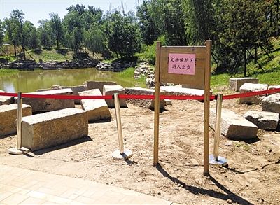 圓明園規(guī)月橋橋體構(gòu)件區(qū)域的警戒線和提示牌。 新京報記者 鄧琦 攝