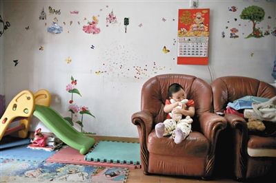 6月14日，未婚媽媽于軍的家里。女兒悅悅抱著兔子玩偶，在聽媽媽手機(jī)上的兒歌，這個(gè)4歲女孩喜歡兔子。