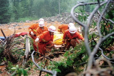 昨日，消防隊員在四川省都江堰市中興鎮(zhèn)三溪村滑坡現(xiàn)場運(yùn)送遇難者遺體。新華社記者 薛玉斌 攝