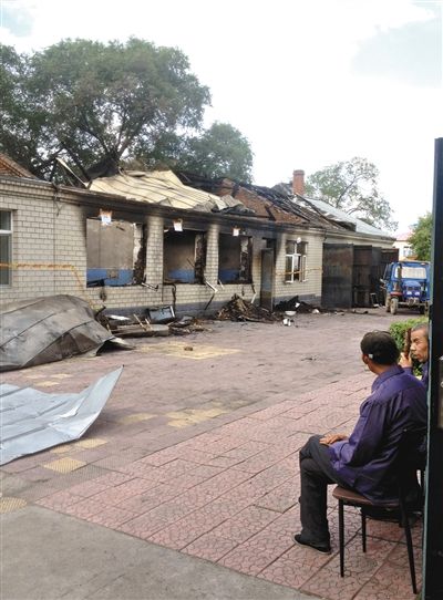 7月27日，海倫聯(lián)合敬老院內(nèi)，幾名老人看著對面被燒毀的特護病房。新京報記者 涂重航 攝