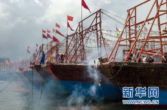 2013年8月1日 南海開漁日 臨高迎新港 8月1日，海南省臨高縣漁民在船上鳴放鞭炮慶祝武蓮港開港。