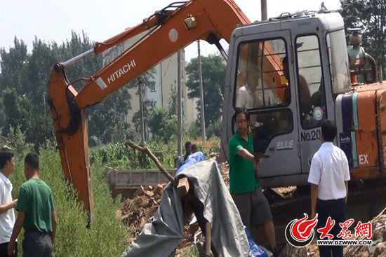陳寶成手持自制刀斧守在挖掘機旁阻止便衣民警靠前。（視頻截圖）