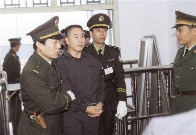 2000年9月30日，河南商丘，胡萬(wàn)林被法警押上法庭。