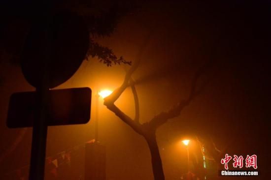 1月31日凌晨，市民行走在煙霧繚繞的南京街頭。當(dāng)天是農(nóng)歷馬年正月初一，南京有限開禁燃放煙花爆竹正逢下霧天，空氣的不流通致使煙花爆竹燃燒后產(chǎn)生的顆粒物不能及時散開，造成整座城市煙霧繚繞。據(jù)當(dāng)?shù)丨h(huán)保部門發(fā)布的信息顯示，空氣質(zhì)量屬重度污染。中新社發(fā) 泱波 攝