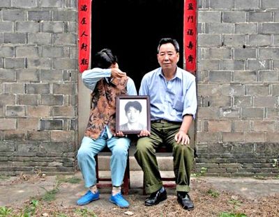 江蘇鎮(zhèn)江，老劉夫婦捧著獨生子的遺像在老家前留影南方都市報供圖L