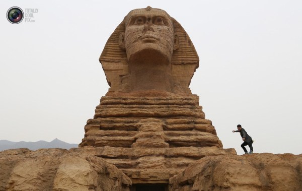 石家莊郊外，一名男子與山寨版獅身人面像合影留念。