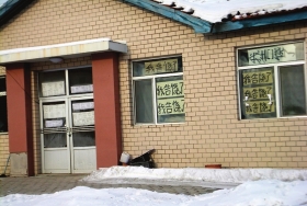 伊春市帶嶺區(qū)一排破舊的平房，房間窗戶上貼滿了“我告饒了”的字樣。