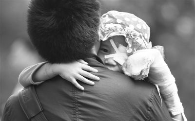 昨日，北京同仁醫(yī)院，被砍傷的彤彤趴在舅舅的肩上。他們剛剛掛完號，正準(zhǔn)備回旅館。新京報記者 尹亞飛 攝