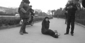 鄭大姐坐在地上，警方趕到進(jìn)行施救。（視頻截圖由警方提供）