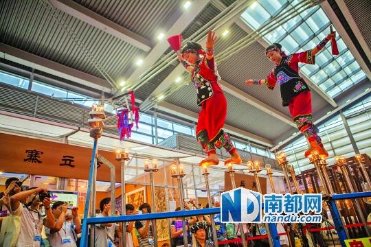 2號(hào)展館，苗族姑娘表演踩燈泡絕技《電光玫瑰》，赤腳踩上40瓦的燈泡并做出高難度動(dòng)作。 南都記者 霍健斌 攝