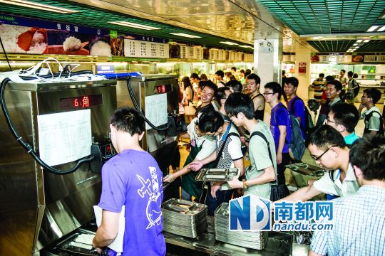 昨日，華南理工大學(xué)一食堂內(nèi)，學(xué)生們正在使用新安裝的自動打飯機(jī)打飯。中新社發(fā)