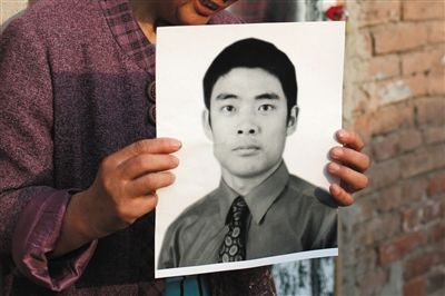 5月19日，朝陽北路，母親捧著張東文的遺像。新京報(bào)記者 侯少卿 攝