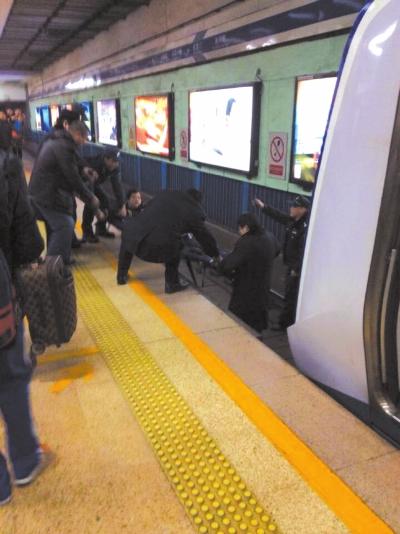 地鐵工作人員將林某從站臺下救起。網(wǎng)友供圖