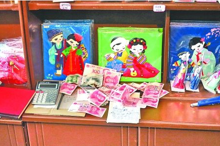 　　2012年6月21日，在朝鮮羅先特別市的一家商店里，柜臺上散落著一些人民幣。在朝鮮，人民幣比本國