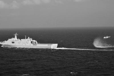 11日，抵達馬航飛機失聯(lián)海區(qū)的海軍井岡山艦與艦載直升機協(xié)同展開立體搜救行動。新華社發(fā)