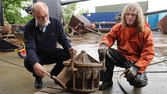 丹麥潛水員安德森（左）展示其打撈上來的U-78潛艇殘骸。