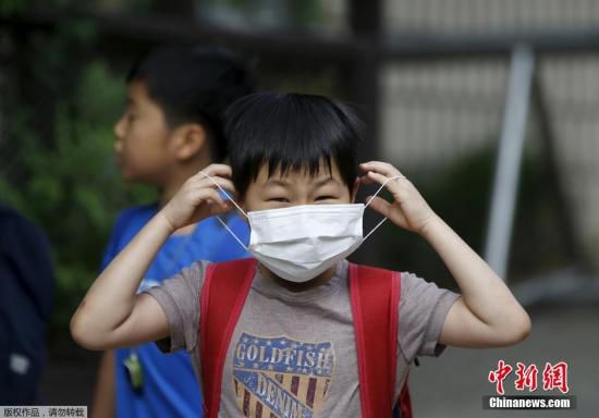 圖為當(dāng)?shù)貢r間2015年6月8日，韓國未停課的學(xué)校，學(xué)生課前戴口罩測體溫。