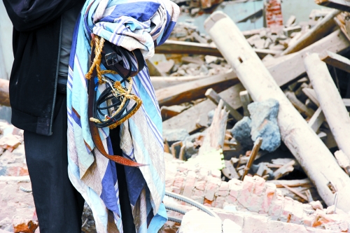 老人手中拿著曾控制住他的電線、床單