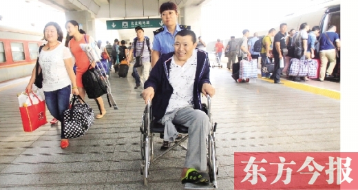 李剛手術(shù)后歸來，在車站工作人員幫助下走出鄭州火車站站臺  東方今報首席記者 張曉冬 攝