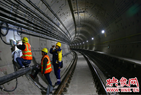 設(shè)施設(shè)備部通號室信號專業(yè)工程師正帶領(lǐng)著同事們進行軌道信號轉(zhuǎn)轍機零件更換。