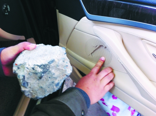 “飛”進(jìn)寶馬車內(nèi)的大石塊,將寶馬車的車門內(nèi)飾板砸爛。