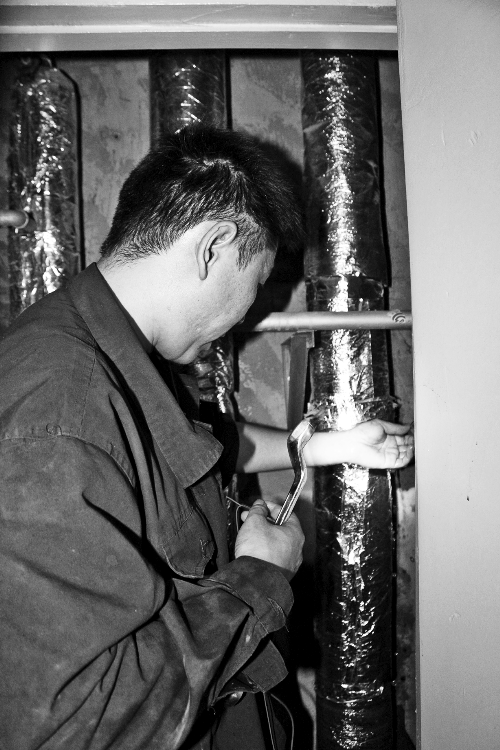 苗師傅一邊進行維修，一邊用耳機接聽市民的電話。