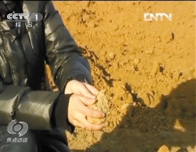 麻剛沙系麻剛石粉碎而成。記者找到一塊麻剛石，一捏就碎成粉末，硬度非常差。央視截圖