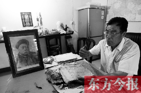 　魏樹紹手拿《物權(quán)法講義》手稿，在講訴先祖書寫“物權(quán)法”的歷史（相框里就是魏聯(lián)奎）